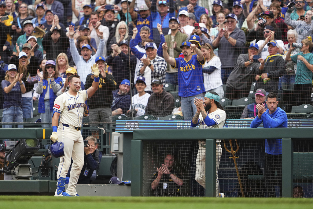 Seattle Mariners' Cal Raleigh waves to the crowd from the dugout after hitting his 54th home run of the season, a two-run home run to tie Mickey Mantle for most home runs by a switch-hitter in a single season, against the Los Angeles Angels during the first inning of a baseball game Sunday, Sept. 14, 2025, in Seattle. (AP Photo/Lindsey Wasson)