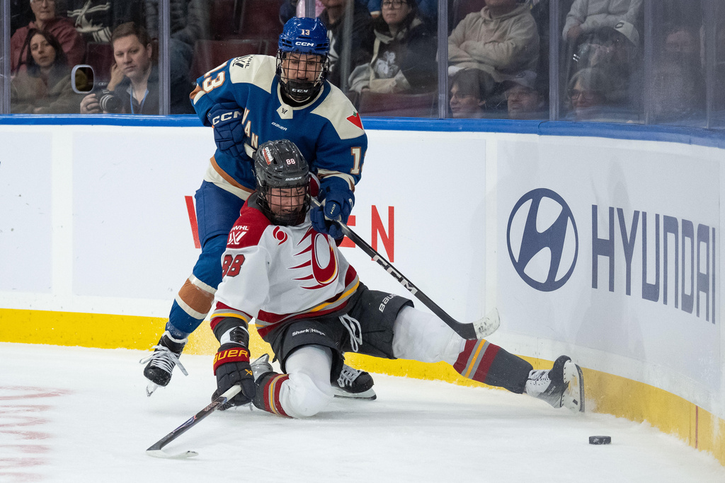 Vancouver Goldeneyes' Tereza Vanisova (13) and Ottawa Charge's Ronja Savolainen (88) vie for the puck period of a PWHL hockey game in Vancouver, British Columbia, Saturday, March 14, 2026. (Ethan Cairns/The Canadian Press via AP)