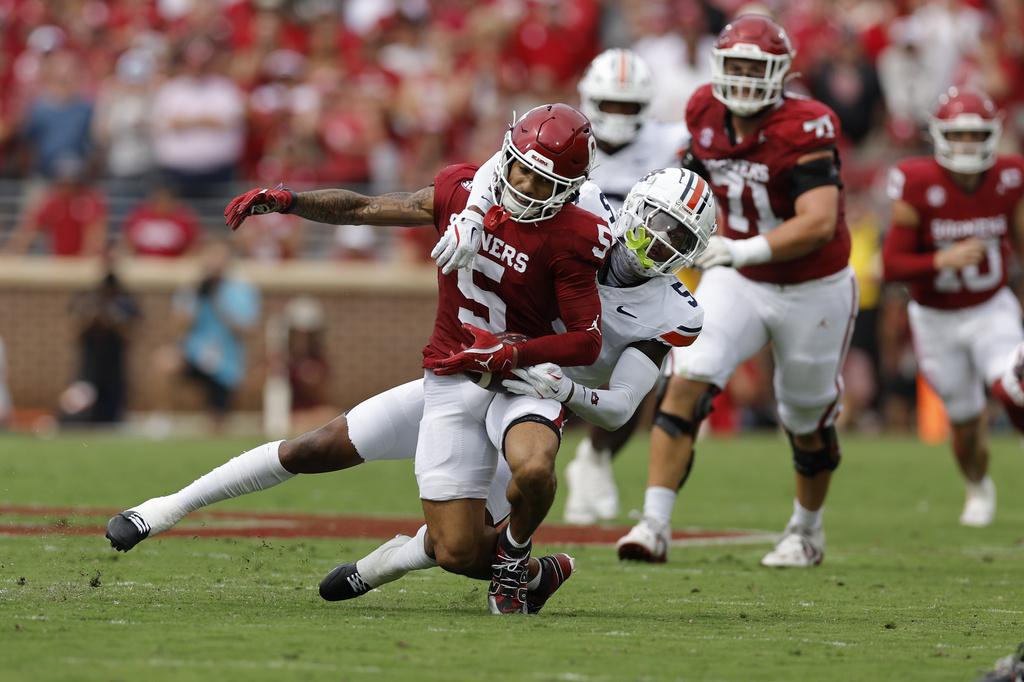 Auburn safety Jahquez Robinson (5) brings down Oklahoma wide receiver Isaiah Sategna III (5) on a play during the first half of an NCAA college football game Saturday, Sept. 20, 2025, in Norman, Okla. (AP Photo/Alonzo Adams)