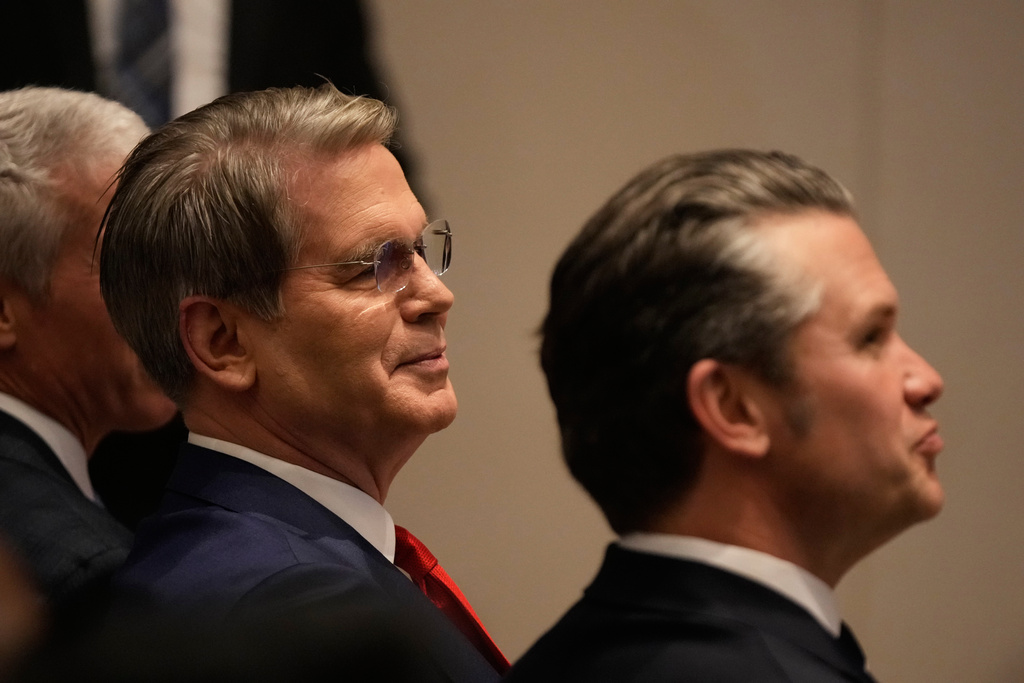 Treasury Secretary Scott Bessent, left, sits next to Defense Secretary Pete Hegseth as President Donald Trump speaks at the Shield of the Americas Summit, Saturday, March 7, 2026, at Trump National Doral Miami in Doral, Fla.(AP Photo/Mark Schiefelbein)