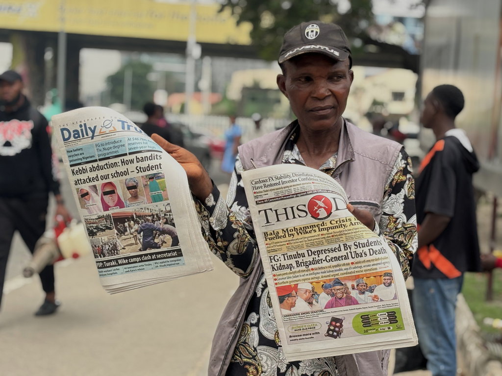A vendor display local newspapers on the street of Lagos with headlines of the Government Girls Comprehensive Secondary School, where gunmen on Monday attacked the school dormitory, abducted schoolgirls, in Kebbi Nigeria, Wednesday, Nov. 19 2025. (AP Photo/Sunday Alamba )