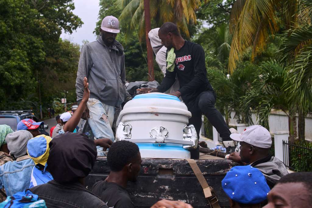 People prepare to transport the body of a relative, a victim of a deadly stampede, to their home, in Milot, Haiti, Sunday, April 12, 2026. (AP Photo/Ketlain Difficile)