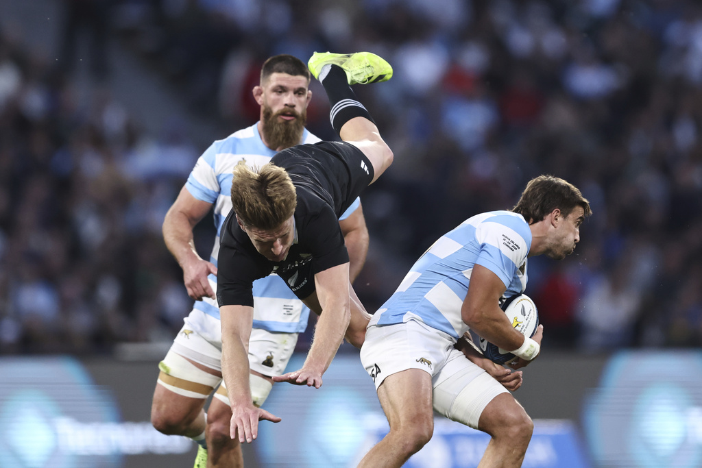Argentina's Los Pumas Juan Cruz Mallia, right, clutches the ball as New Zealand's All Blacks Jordie Barrett takes a fall during a rugby championship match at Mario Alberto Kempes stadium in Cordoba, Argentina, Saturday, Aug. 16, 2025. (AP Photo/Nicolas Aguilera)