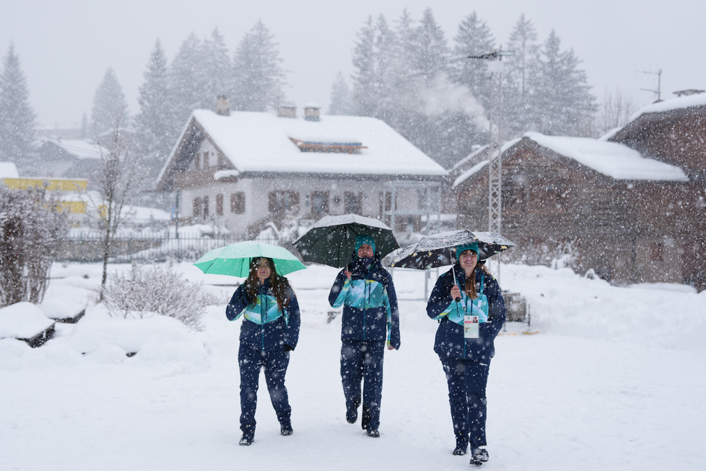 Volunteers walk to an Olympic venue ahead of the 2026 Winter Olympics, in Cortina d'Ampezzo, Italy, Wednesday, Feb. 4, 2026. (AP Photo/Misper Apawu)