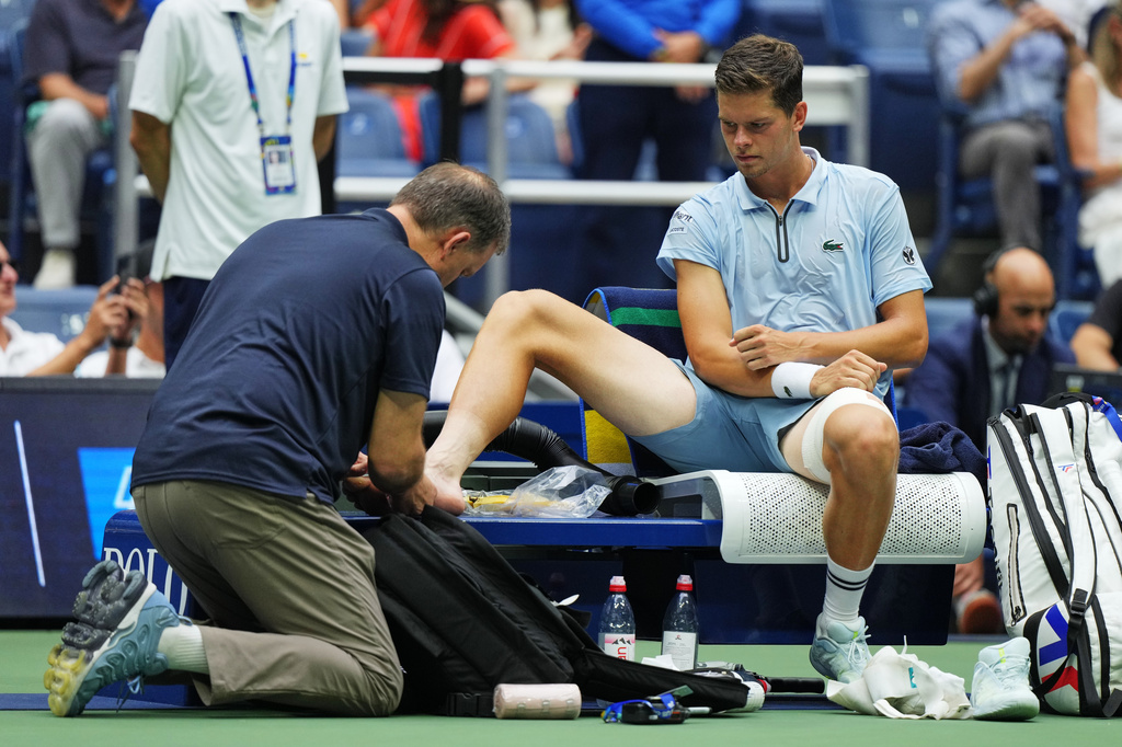 Alexander Blockx, of Belgium, has his foot checked during a medical timeout during a match against Karen Khachanov, of Russia, during the quarterfinal round of the U.S. Open tennis championships, Wednesday, Sept. 9, 2026, in New York. (AP Photo/Kirsty Wigglesworth)