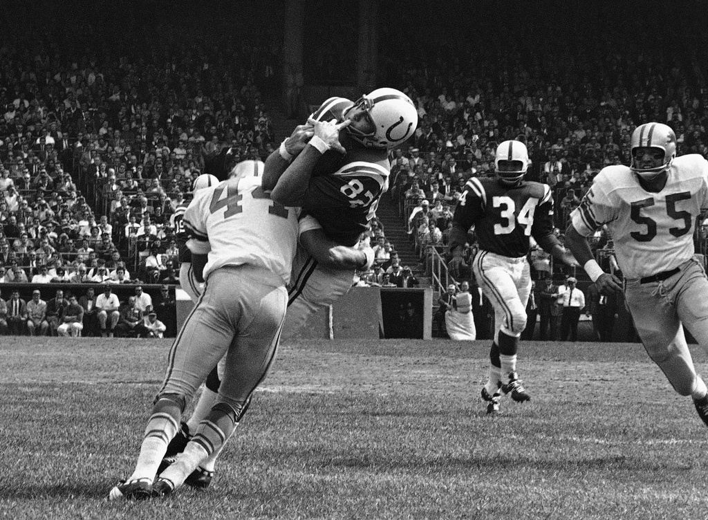 FILE - In this Sept. 30, 1962, file photo, Baltimore Colts end Raymond Berry snags a pass from quarterback John Unitas for 5-yard gain against the Detroit Lions in a football game in Baltimore. Lions' Dick LeBeau (44) makes the tackle. (AP Photo/File)