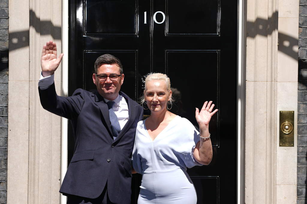 Britain's new Prime Minister Andy Burnham and his wife Marie-France van Heel wave as they arrive at 10 Downing Street in London, Monday, July 20, 2026.(AP Photo/Kirsty Wigglesworth)