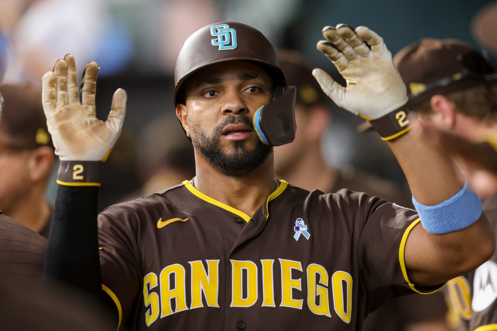San Diego Padres' Xander Bogaerts (2) celebrates in the dugout after scoring during the fourth inning of a baseball game against the Texas Rangers, Sunday, June 21, 2026, in Arlington, Texas. (AP Photo/Gareth Patterson)