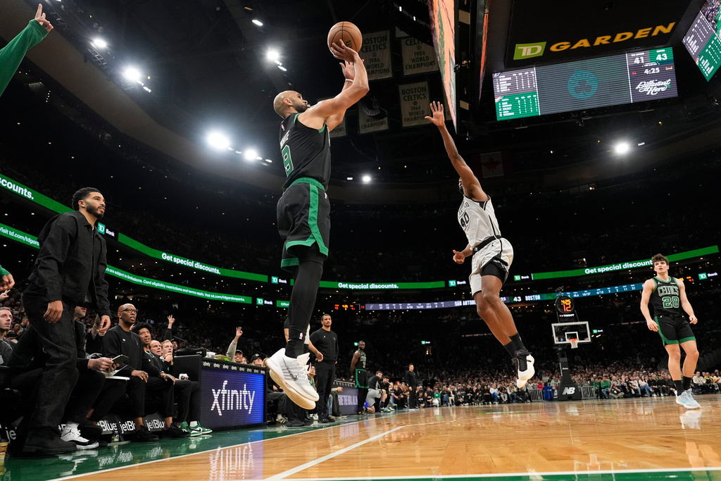 Boston Celtics guard Derrick White (9) soots over San Antonio Spurs forward Harrison Barnes (40) during the first half of an NBA basketball game, Saturday, Jan. 10, 2026, in Boston. (AP Photo/Robert F. Bukaty)