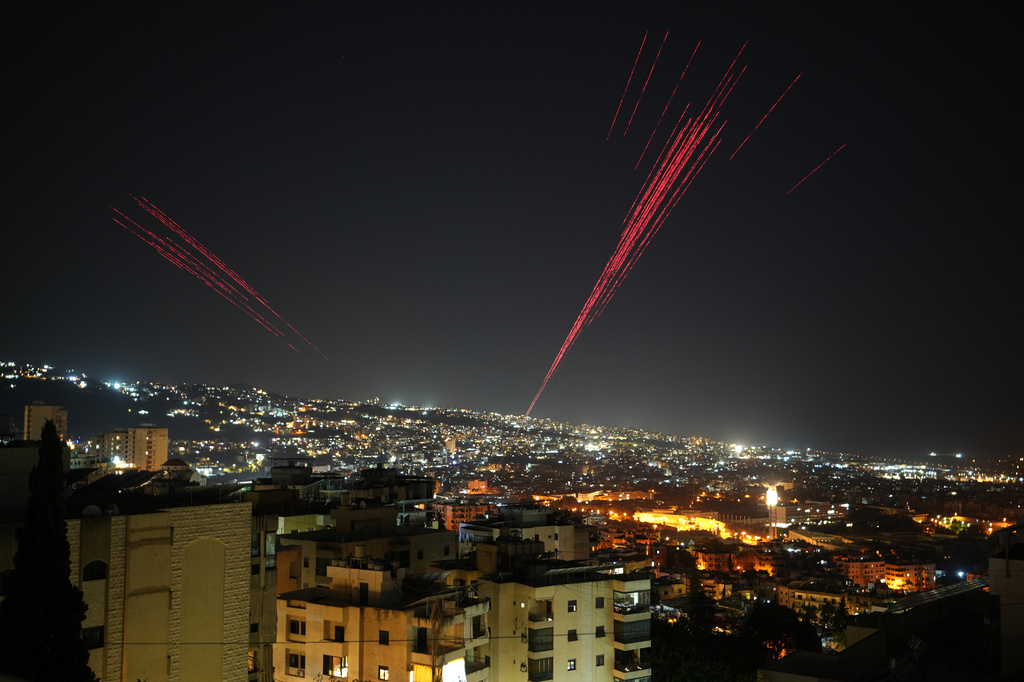 Tracer rounds illuminate the night sky as people fire live ammunition and fireworks into the air following a ceasefire between Israel and Hezbollah, in Beirut, Lebanon, early Friday, April 17, 2026. (AP Photo/Hassan Ammar)