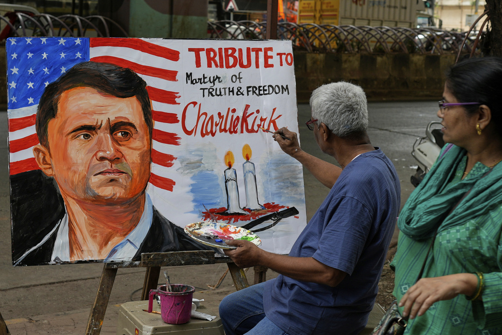 A teacher from Gurukul school of Art completes artwork to pay tribute to Charlie Kirk who was shot and killed, in Mumbai, India, Thursday, Sept. 11, 2025. (AP Photo/Rajanish Kakade)