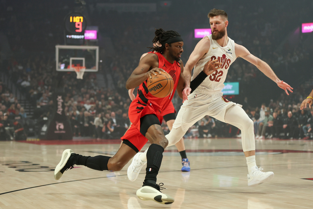 Portland Trail Blazers forward Jerami Grant, left, drives to the basket as Cleveland Cavaliers forward Dean Wade (32) defends during the first half of an NBA basketball game Sunday, Feb. 1, 2026, in Portland, Ore. (AP Photo/Amanda Loman)