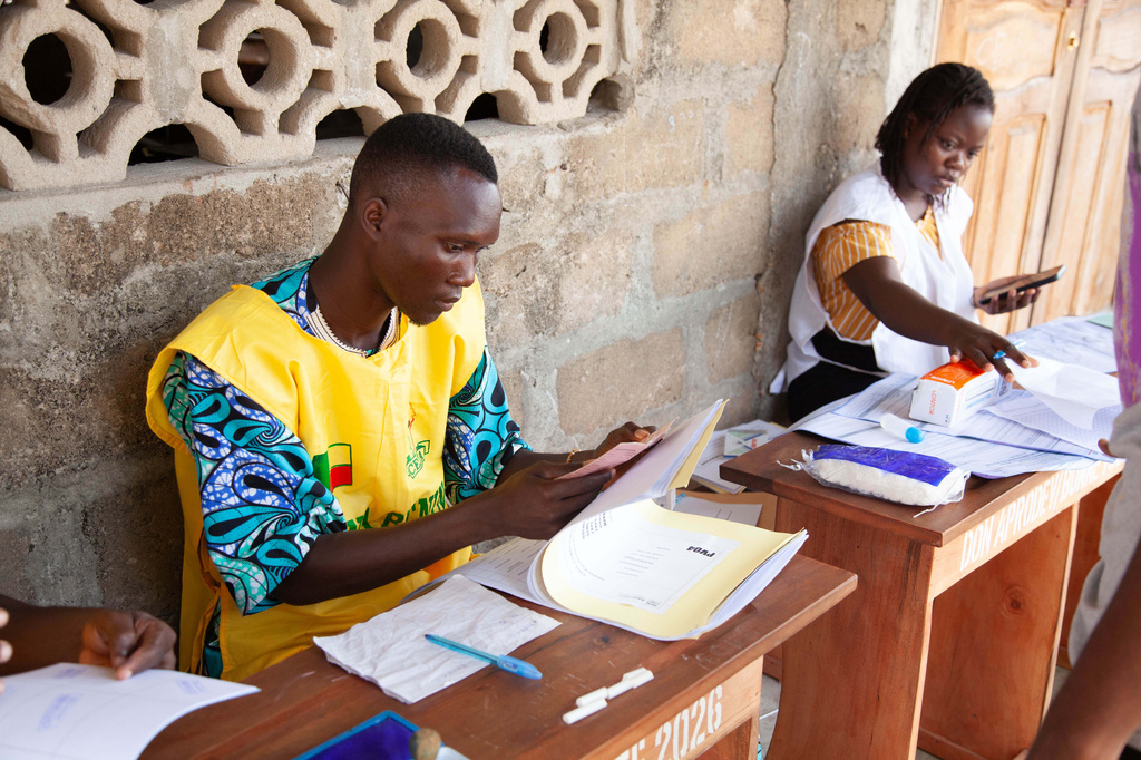 Electoral officials prepare presidential ballot papers at a polling station in Cotonou, Benin, Sunday, April 12, 2026. (AP Photo/Abadjaye Justin Sodogandji)