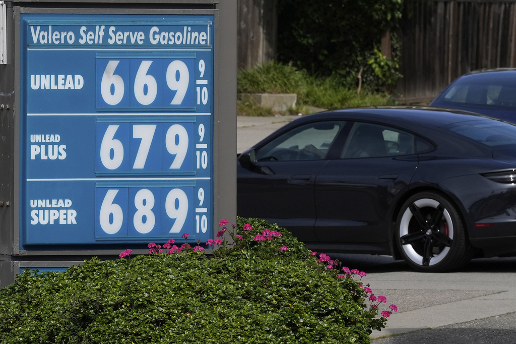 A car drives behind the gasoline price board at a Valero gas station in San Francisco, Saturday, April 4, 2026. (AP Photo/Jeff Chiu)