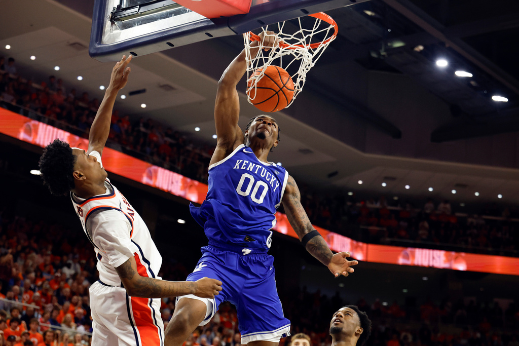 Kentucky guard Otega Oweh (00) slam dunks the ball over Auburn guard Tahaad Pettiford (0) during the first half of an NCAA college basketball game Saturday, Feb. 21, 2026, in Auburn, Ala. (AP Photo/Butch Dill)