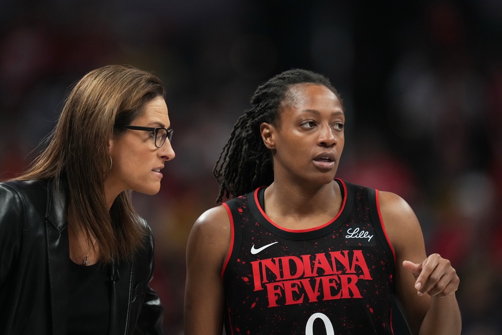 Indiana Fever head coach Stephanie White talks with Kelsey Mitchell during second half of Game 3 of a WNBA basketball playoff semifinals series against the Las Vegas Aces, Friday, Sept. 26, 2025, in Indianapolis. (AP Photo/Darron Cummings)