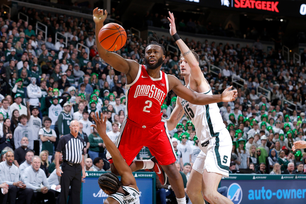 Ohio State guard Bruce Thornton (2), center, loses the ball as he is fouled by Michigan State guard Jeremy Fears Jr., bottom left, as Michigan State center Carson Cooper (15), right, defends during the first half of an NCAA college basketball game, Sunday, Feb. 22, 2026, in East Lansing, Mich. (AP Photo/Al Goldis)