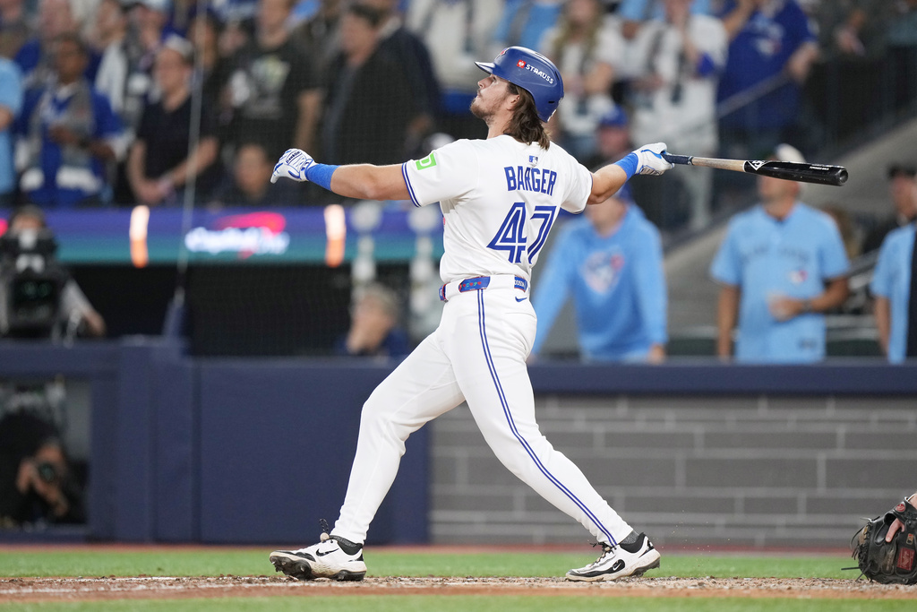 Toronto Blue Jays' Addison Barger watches the ball as he hits a grand slam against the Los Angeles Dodgers during the sixth inning in Game 1 of baseball's World Series, Friday, Oct. 24, 2025, in Toronto. (Nathan Denette/The Canadian Press via AP)