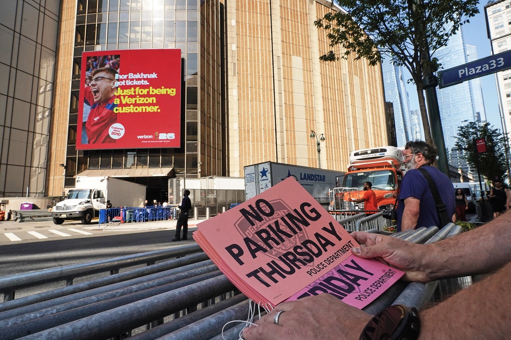 A worker holds "No Parking" signs prior to posting as trucks fill the loading dock outside New York's Madison Square Garden, Wednesday, July 1, 2026. (AP Photo/Richard Drew)