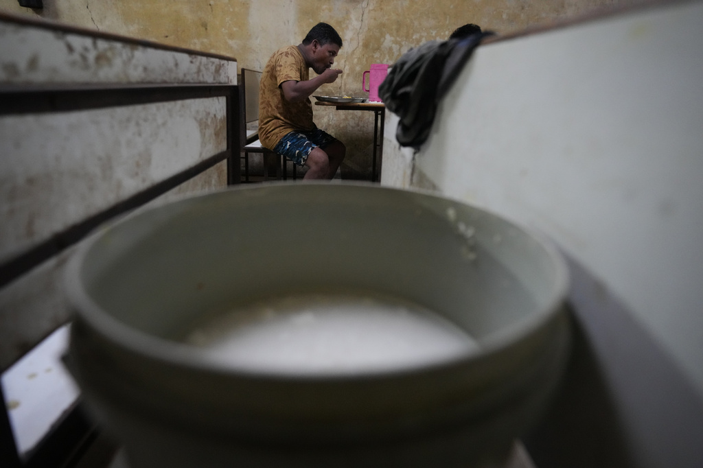 Power loom factory worker Sibaram Pradhan eats dinner at a hotel at his residential quarters in Surat, India, Wednesday, May 27, 2026. (AP Photo/Ajit Solanki)