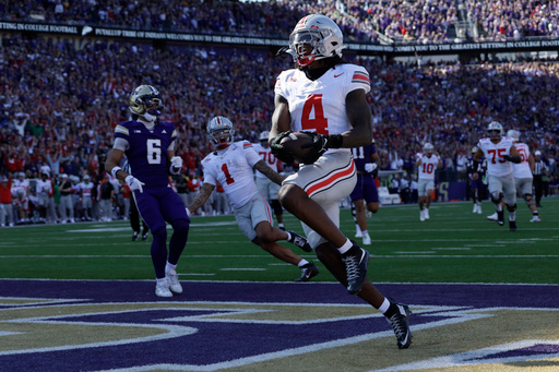 Ohio State wide receiver Jeremiah Smith (4) scores on a pass run play against the Washington during the first half of an NCAA college football game, Saturday, Sept. 27, 2025, in Seattle. (AP Photo/John Froschauer) Ohio State wide receiver Jeremiah Smith (4) scores on a pass run play against the Washington during the first half of an NCAA college football game, Saturday, Sept. 27, 2025, in Seattle. (AP Photo/John Froschauer)