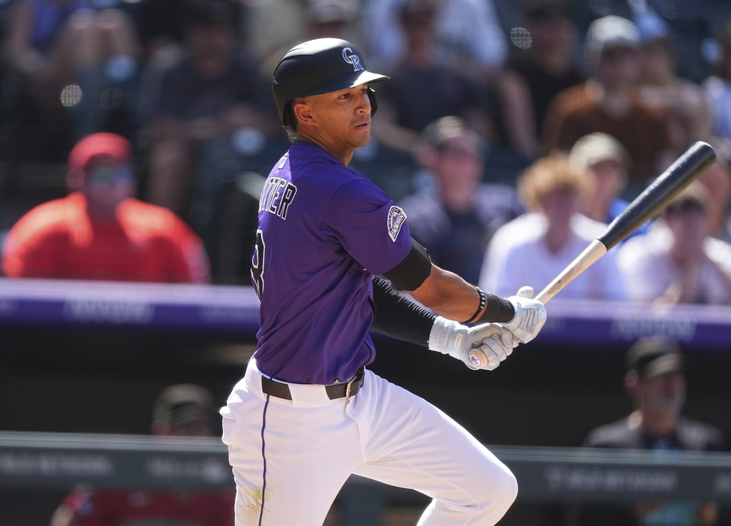 Colorado Rockies' Ryan Ritter singles to drive in two runs off Arizona Diamondbacks relief pitcher Jake Woodford in the seventh inning of a baseball game, Sunday, Aug. 17, 2025, in Denver. (AP Photo/David Zalubowski)