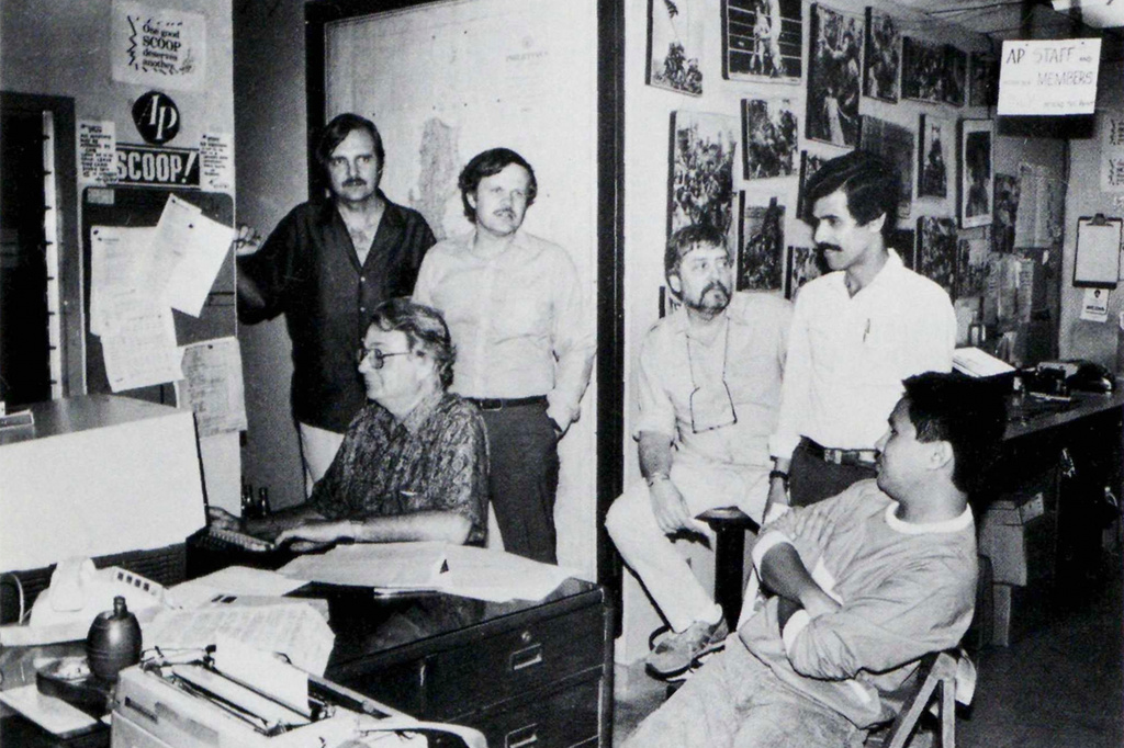 In this undated photo published in The AP World in 1986, Associated Press staffers, from left, Singapore bureau chief Ken Whiting, Bangkok bureau chief Denis Gray, Manila bureau chief David Briscoe, Asia news editor Richard Pyle, Manila news editor Mike Suarez and Manila reporter Alex Gaw confer on a story at the Manila bureau. (AP Photo)