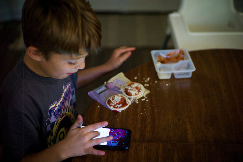 Taylor Moyer's oldest son Liam eats a Lunchable while playing with a phone at home, Sunday, Oct. 5, 2025, in Virginia Beach, Va. (AP Photo/John Clark)