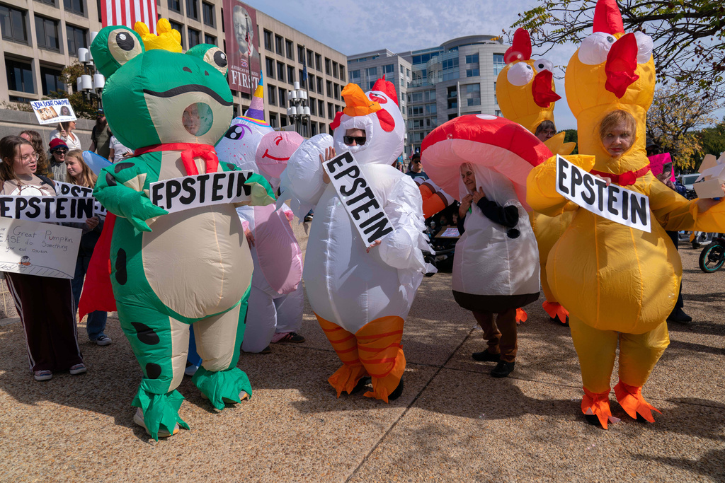 Demonstrators in inflatable costumes rally on Pennsylvania Avenue during a No Kings protest in Washington, Saturday, Oct. 18, 2025. (AP Photo/Jose Luis Magana)