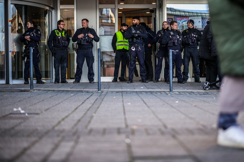 Police officers stand in front of the savings bank branch in the Buer district in Gelsenkirchen, Germany, Tuesday, Dec. 30, 2025 following a break-in into the bank's vault. (Christoph Reichwein/dpa via AP)
