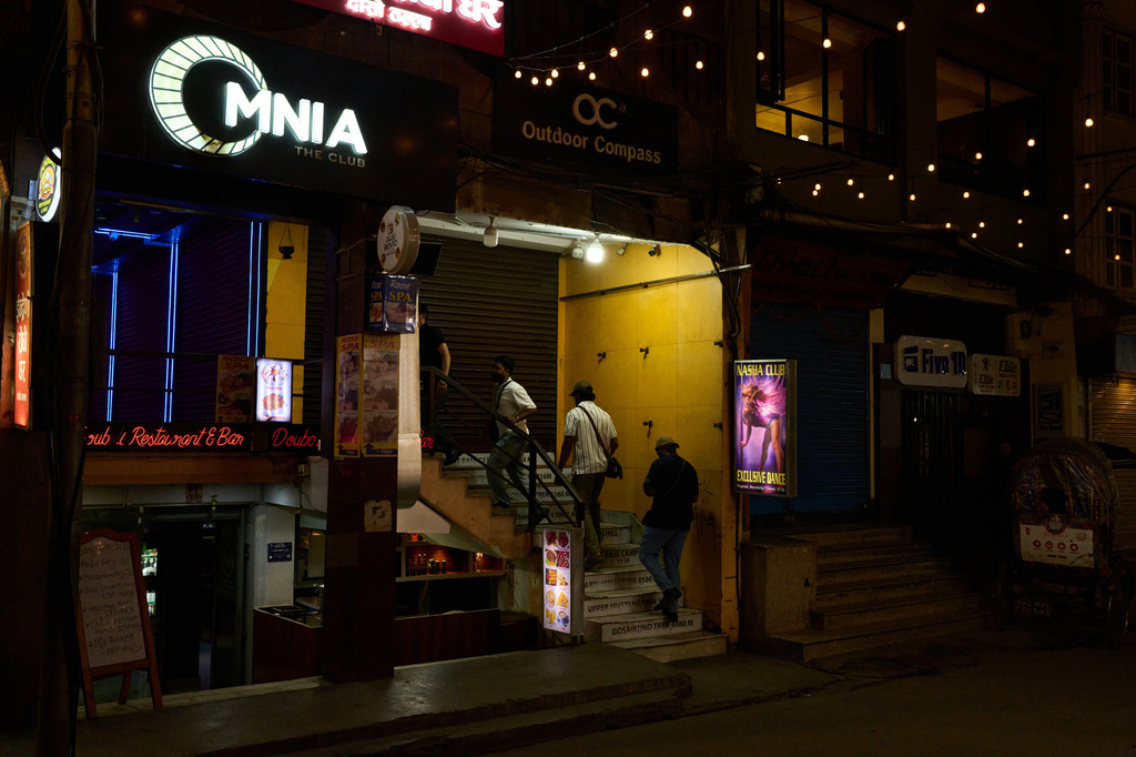 Men enter a club in Kathmandu, Nepal, Thursday, May 21, 2026. (AP Photo/Bram Janssen)
