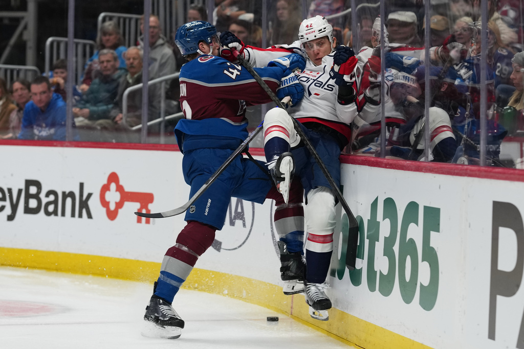 Colorado Avalanche defenseman Josh Manson, left, delivers a hard check to Washington Capitals left wing Anthony Beauvillier in the second period of an NHL hockey game Monday, Jan. 19, 2026, in Denver. (AP Photo/David Zalubowski)