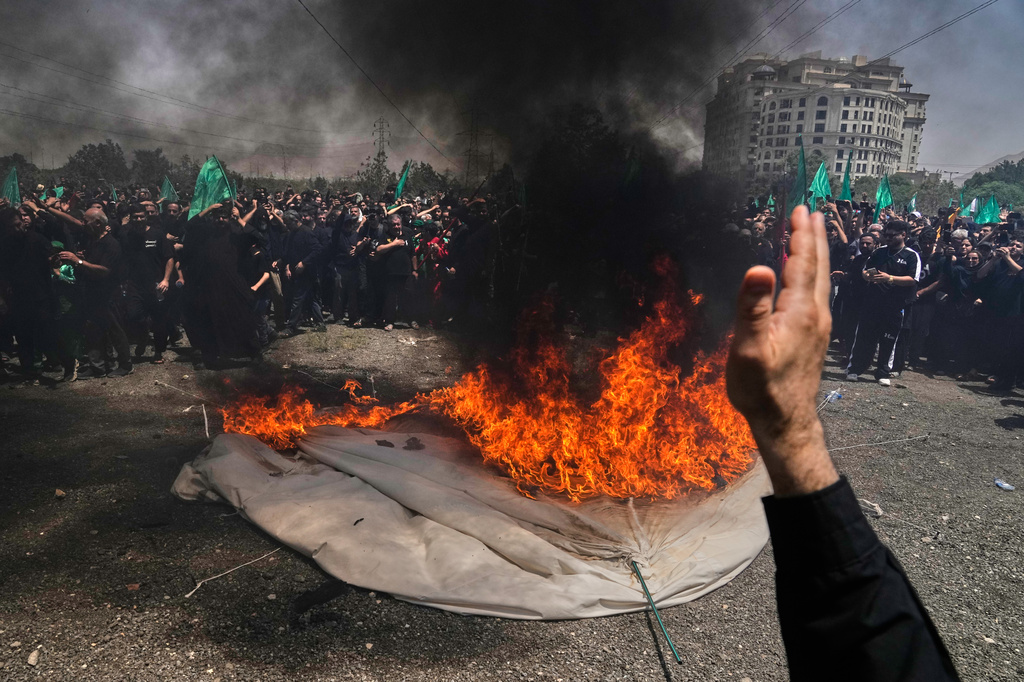 People mourn as a tent is set on fire in Tehran, Iran, Thursday, June 25, 2026, during re-enactment of the battle of Karbala in A.D. 680 in present-day Iraq, in which Imam Hussein, a grandson of the Prophet Muhammad, one of Shiite Islam's most beloved saints, and his family and companions were killed after refusing to pledge allegiance to the Umayyad caliphate. (AP Photo/Vahid Salemi)