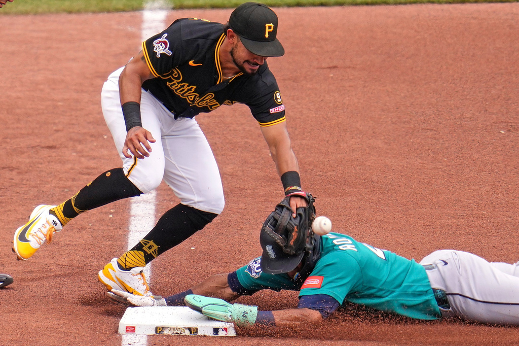 Seattle Mariners' Julio Rodríguez, right, slides safely into third base with a stolen base as the ball gets away from Pittsburgh Pirates third baseman Nick Gonzales during the fourth inning of a baseball game in Pittsburgh, Thursday, June 25, 2026. (AP Photo/Gene J. Puskar)