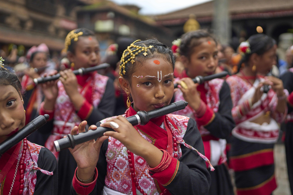 Young devotees play flute as they participate in a parade celebrating the birthday of Lord Krishna on Krishna Janmashtami in Bhaktapur,Nepal, Saturday, Aug. 16, 2025. (AP Photo/Niranjan Shrestha)