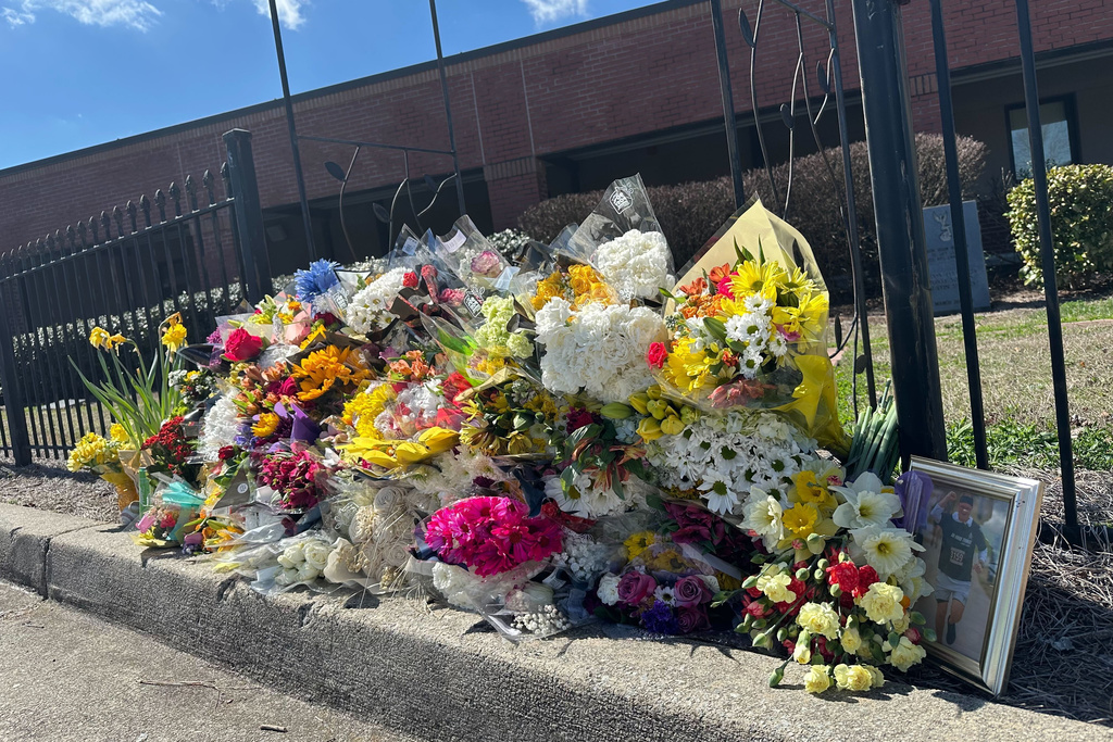 Flowers lie along a fence outside North Hall High School in Gainesville, Ga., on Monday, March 9, 2026. (AP Photo/Emilie Megnien)