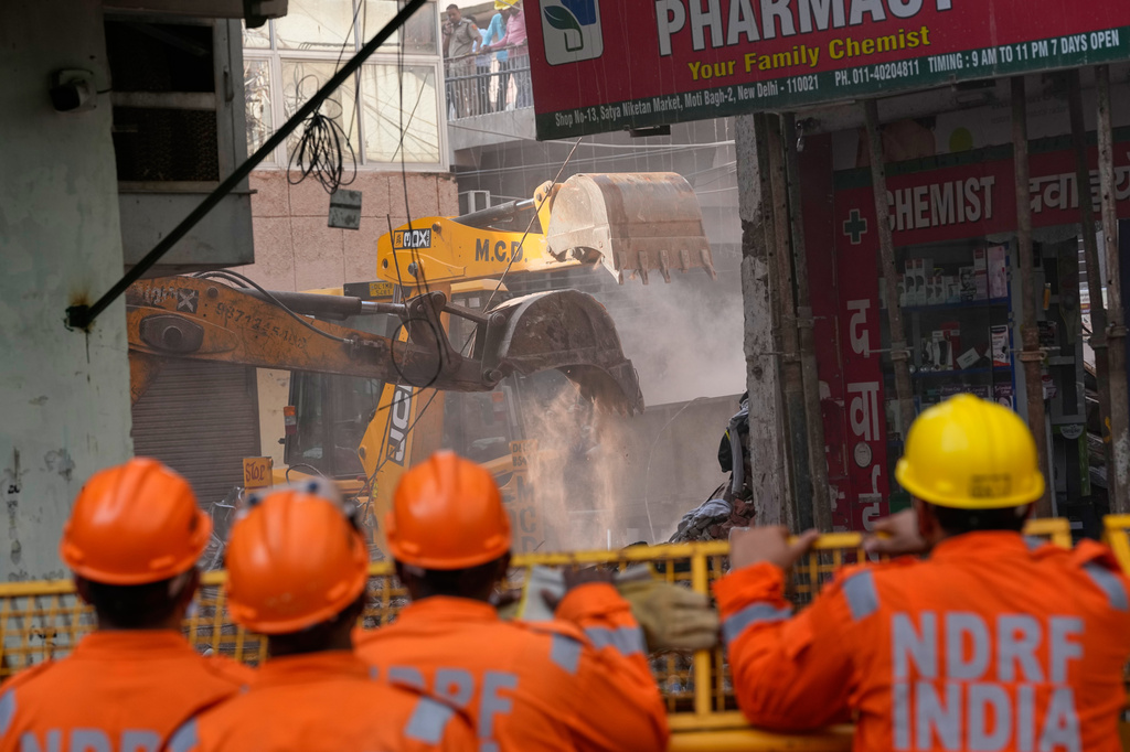 Rescuers clear debris as they search for people possibly trapped at the site of a collapsed building in New Delhi, India, Monday, Sept. 7, 2026. (AP Photo/Manish Swarup)