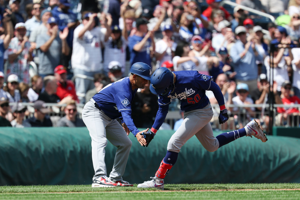 Los Angeles Dodgers' Mookie Betts. low-fives third base coach Dino Ebel after hitting a two-run home run against Washington Nationals during the third inning of an baseball game, Friday, April 3, 2026, in Washington. (AP Photo/Terrance Williams)