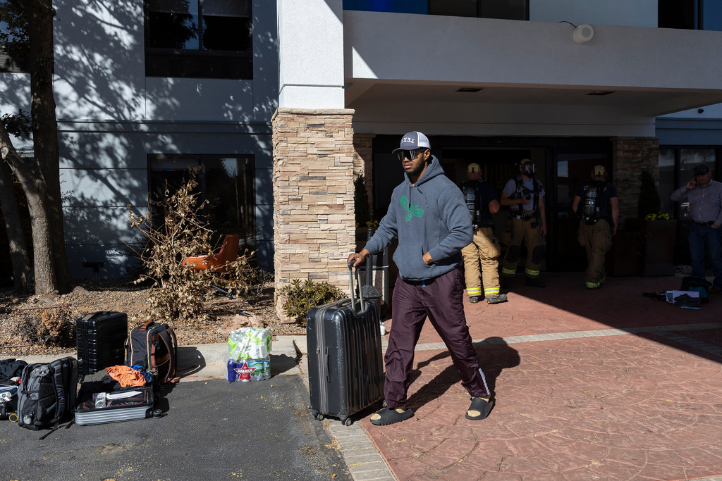 Michael Johnson of Nacogdoches, Texas gathers his belongings from the Holiday Inn Express on Thursday, Nov. 13, 2025 after he was able to return due to evacuation orders following an ammonia gas leak at the hotel in Weatherford, Okla. the previous night. (AP Photo/Alonzo Adams)