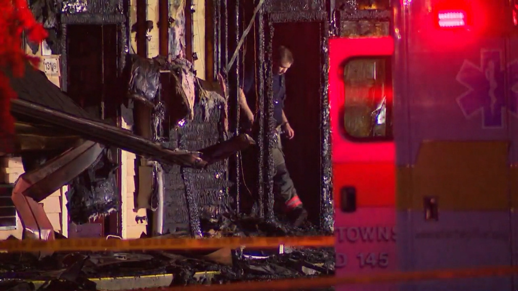 In this photo, taken from video, a firefighter exits the charred remains of an Econo Lodge motel in Wooster, Ohio, where three people died in a blaze early Wednesday, July 1, 2026. (WEWS/via AP)