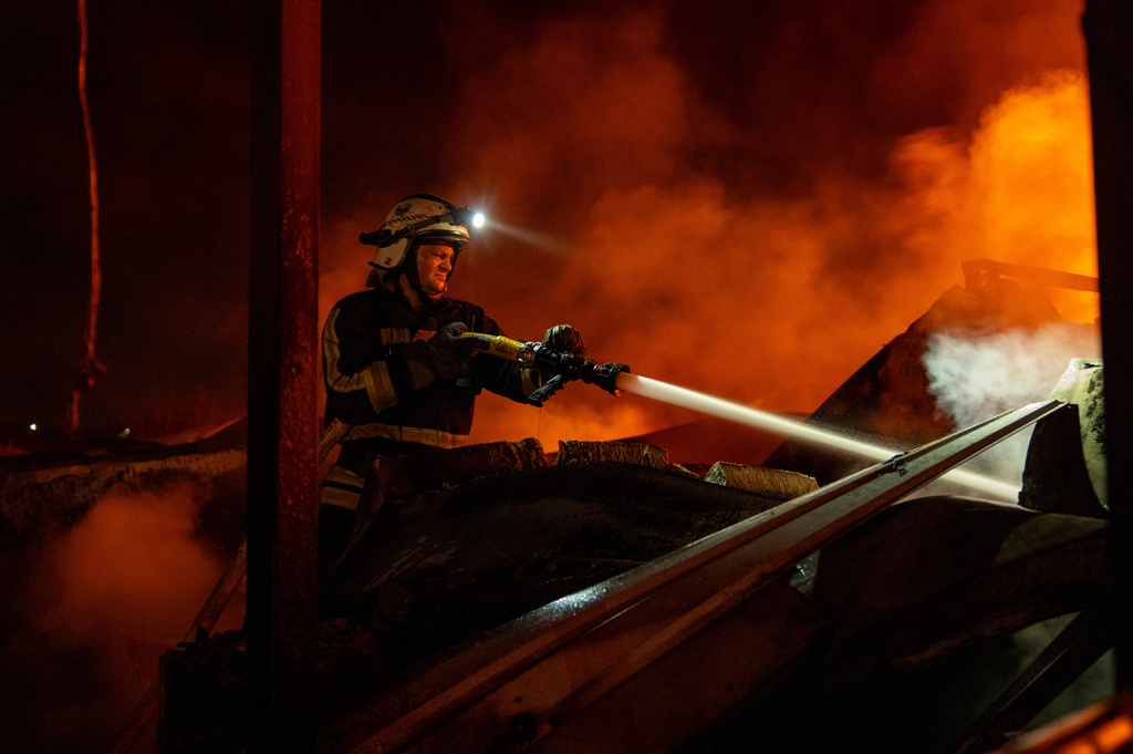 Firefighters put out a fire after Russian missiles hit a warehouse in Kyiv, Ukraine, Wednesday, Aug. 5, 2026. (AP Photo/Dan Bashakov)
