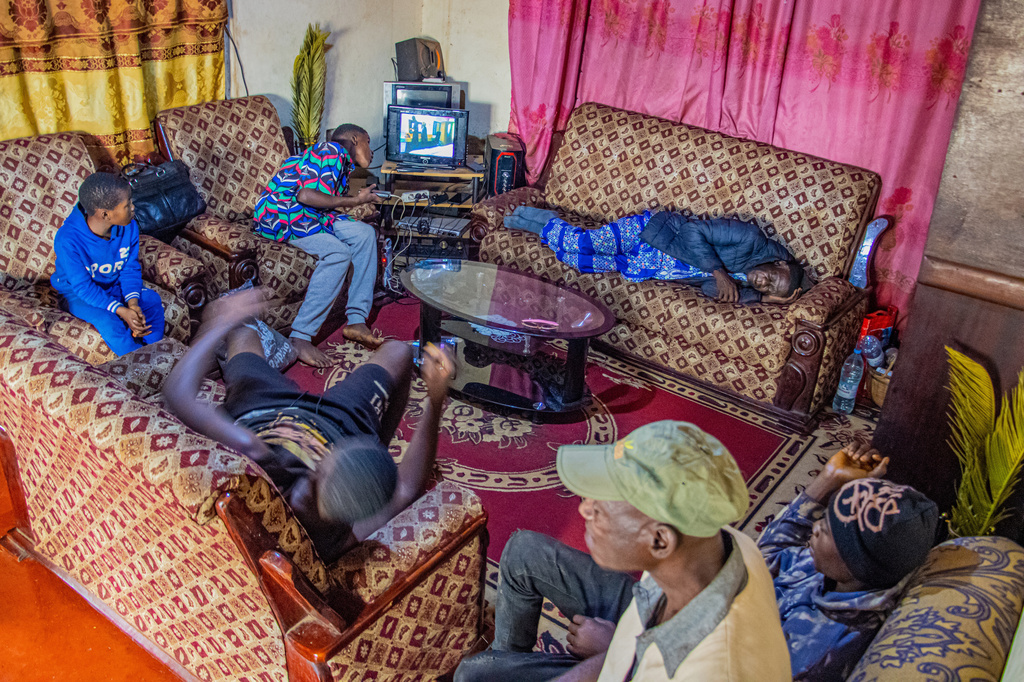 Caro Bih's family watches television in their living room in Bamenda, Cameroon, Monday, April 13, 2026. (AP Photo/Welba Yamo Pascal)
