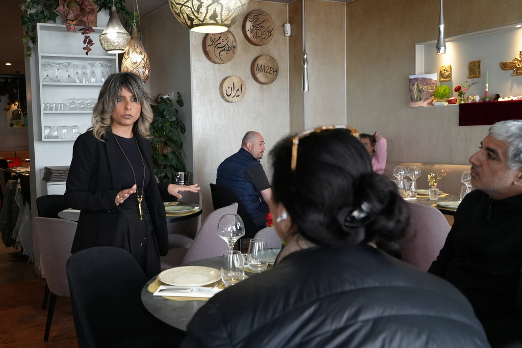 Shayan Ghadimi talks with customers in her restaurant in Paris, Thursday, March 19, 2026. (AP Photo/Alexander Turnbull)