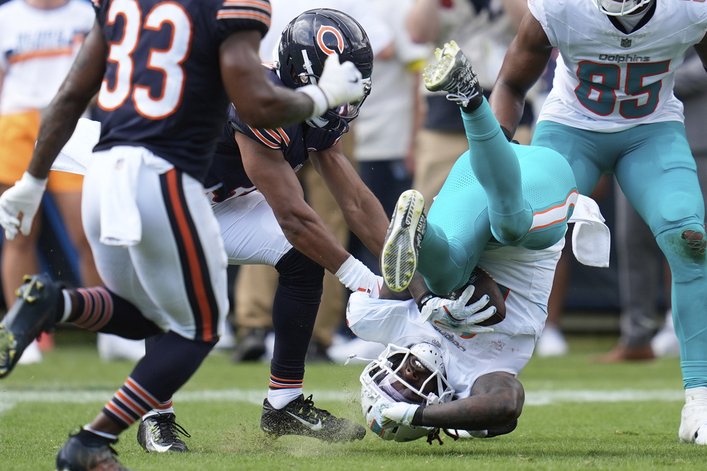 Miami Dolphins running back Alexander Mattison (8) falls to the field during the second half of an NFL preseason football game against the Chicago Bears, Sunday, Aug. 10, 2025, in Chicago. (AP Photo/Erin Hooley)