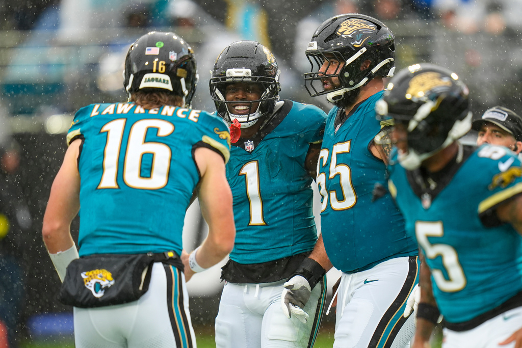Jacksonville Jaguars running back Travis Etienne Jr. (1) celebrates a touchdown with quarterback Trevor Lawrence (16) during the first half of an NFL football game against the Indianapolis Colts, Sunday, Dec. 7, 2025, in Jacksonville, Fla. (AP Photo/John Raoux)