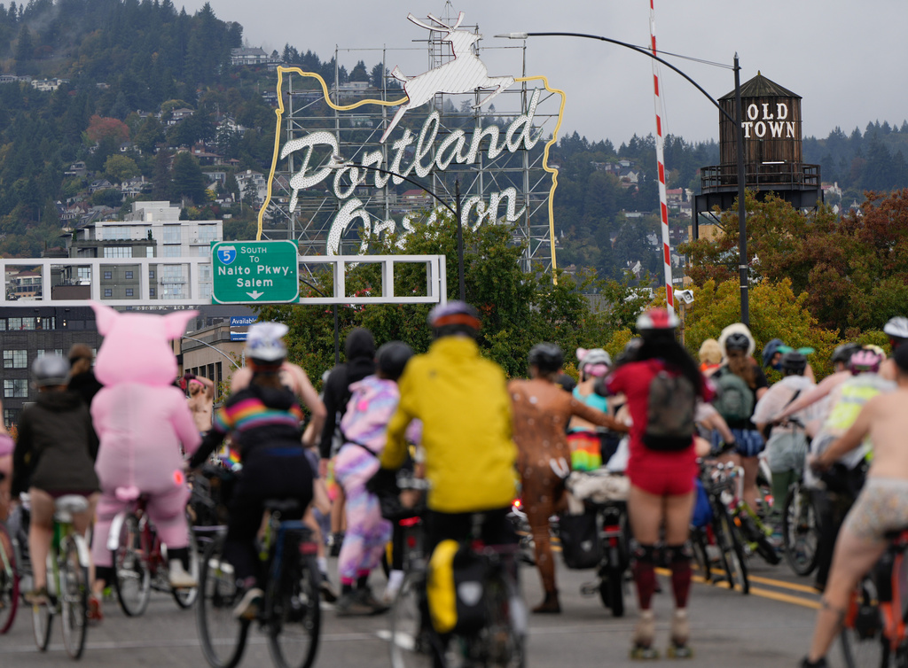 Cyclists in the Naked Bike Ride in protest against Donald Trump's attempts to mobilize the National Guard ride across the Burnside Bridge, Sunday, Oct. 12, 2025, in Portland, Ore. (AP Photo/Jenny Kane)