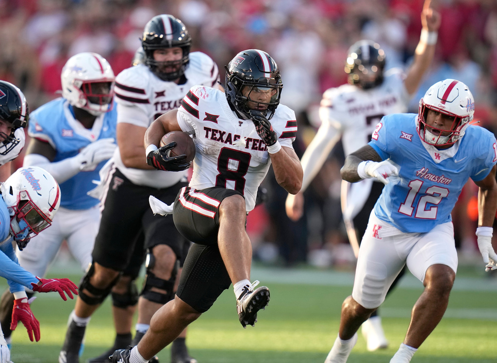 Texas Tech running back Cameron Dickey (8) runs the ball against Houston linebacker Sione Fotu (12) during the first half of an NCAA college football game, Saturday, Oct. 4, 2025, in Houston. (AP Photo/Karen Warren)