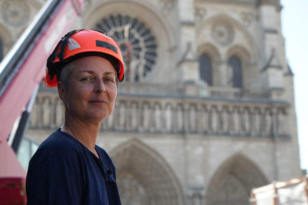 Camille Colonna, archaeologist in charge of operations, wearing a safety helmet, poses in front of Notre-Dame Cathedral during excavations in Paris, Monday, June 1, 2026. (AP Photo/Nicolas Garriga)