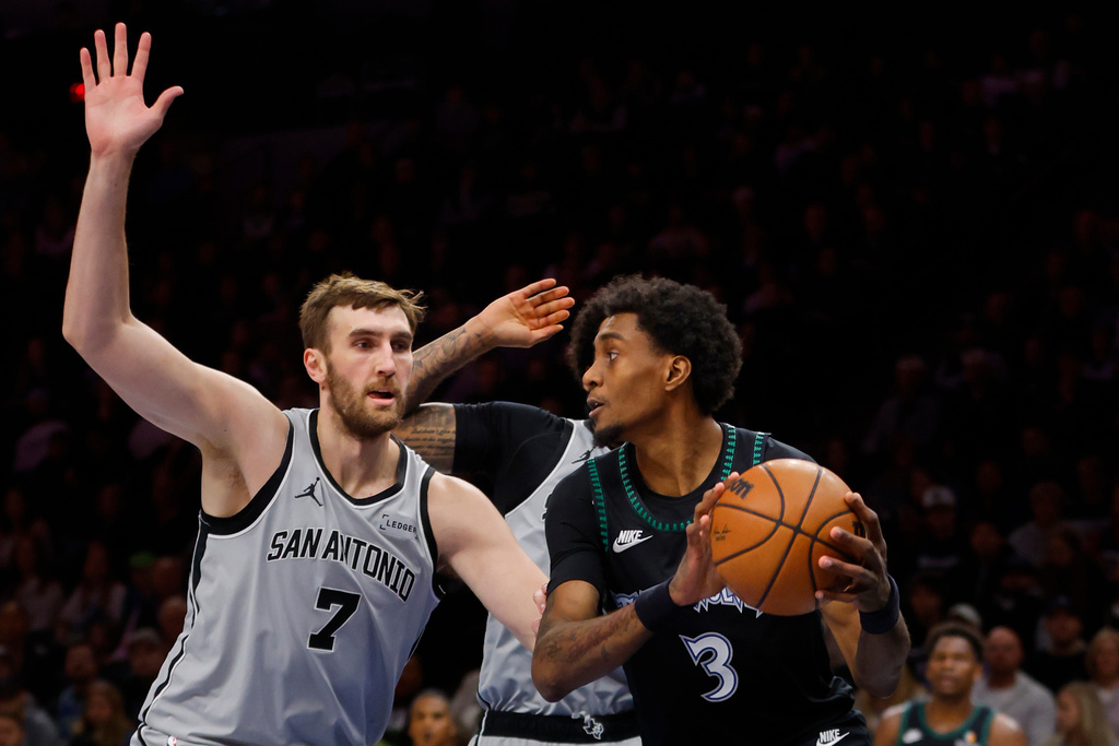 Minnesota Timberwolves forward Jaden McDaniels (3) works around San Antonio Spurs center Luke Kornet (7) in the first quarter of an NBA basketball game Sunday, Nov. 30, 2025, in Minneapolis. (AP Photo/Bruce Kluckhohn)