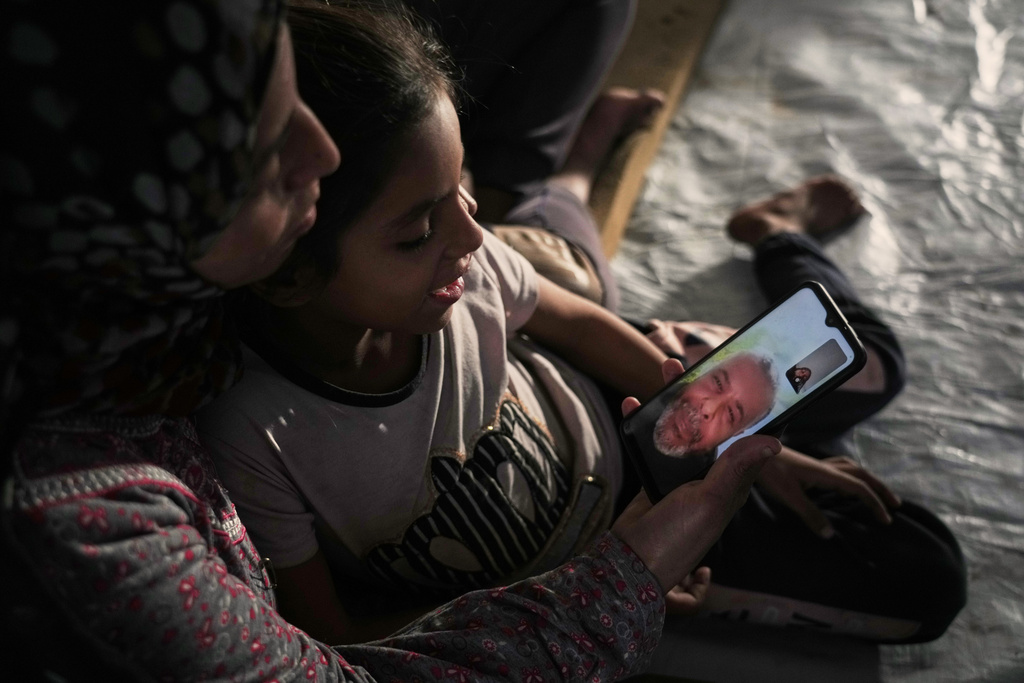 Asmahan Belal and her children speak with Raed, her husband and their father, in a video call from their tent in Gaza City while he has been stranded in Egypt for more than two years, Tuesday, Jan. 27, 2026. (AP Photo/Jehad Alshrafi)